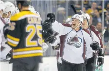  ??  ?? The Avalanche’s John Mitchell, right, celebrates his goal during a game against the Bruins in Boston on Dec. 8, 2016.
