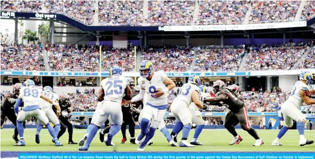  ?? —AFP ?? INGLEWOOD: Matthew Stafford #9 of the Los Angeles Rams hands the ball to Sony Michel #25 during the first quarter in the game against the Tampa Bay Buccaneers at SoFi Stadium on Sunday in Inglewood, California.