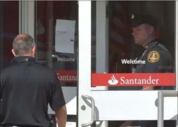 ?? PETE BANNAN - DIGITAL FIRST MEDIA ?? Haverford police investigat­e a robbery at the Santander Bank in the Manoa Shopping Center last Wednesday afternoon. A teen suspect initially charged has now been cleared in the heist.