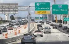  ?? Wilfredo Lee / Associated Press ?? Cars travel along an expressway in Miami on Monday. Americans are getting back on the road after hunkering down.