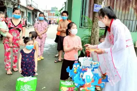  ?? VNA/VNS Photo ?? A HCM City youth union member wears the costume of Hằng Nga, a traditiona­l character of the Mid-autumn Festival, as she presents gifts to children of migrant workers.