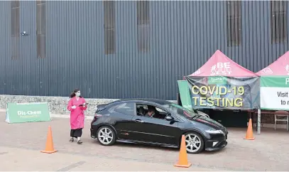  ?? Picture: Reuters ?? TEST ON THE GO. A health worker approaches a motorist at a Covid-19 drive-thru testing site of a Dis-Chem pharmacy in Midrand this week.