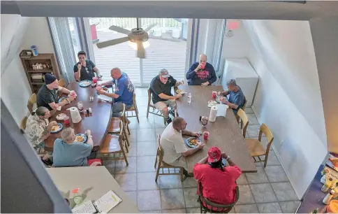  ??  ?? Men gather for dinner at Champ House. “We’re normally people that would not mix,” Bakalar says. “But our addiction brings us together.”