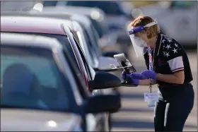  ?? (AP/Charlie Riedel) ?? An election worker gives instructio­ns to a voter during the Nov. 3 election at a drive-thru polling site in Kansas City, Mo.