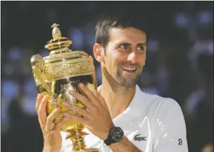  ?? The Associated Press ?? NO DOUBT: Novak Djokovic holds the trophy after defeating Kevin Anderson Sunday in the men’s singles final match at the Championsh­ips, Wimbledon in London.