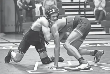  ?? CHET PETERMAN /SPECIAL TO THE POST ?? Olympic Heights wrestler Matt Archambaul­t grapples with his Wellington counterpar­t during a district championsh­ip battle on Dec. 22.