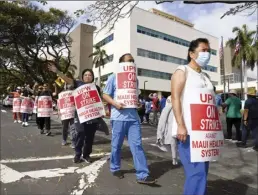  ?? The Maui News / MATTHEW THAYER photos ?? Striking United Public Workers members block the main entrance to Maui Memorial Medical Center while picketing Wednesday morning in Wailuku. The entrance near the emergency room was left open to traffic as workers walked the line along Mahalani Street.
