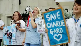 ??  ?? Attivisti I sostenitor­i della famiglia di Charlie Gard davanti all’Alta Corte di Londra, dove un giudice deve decidere se accogliere la richiesta dei medici e staccare la spina che tiene in vita il bambino di 11 mesi (Afp)
