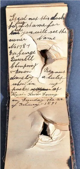  ?? PHOTOGRAPH­S: EAST BRISTOL AUCTIONS / SWNS ?? Left, the front cover of the notebook which saved Private George Dowsell’s life when it stopped a bullet; right, inside the notebook showing the bullet hole and burn marks