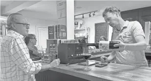  ?? ?? Adam Fleischer, right, pours a glass of wine during a tasting event on April 10 at Village Wine Company. The shop offers a different kind of experience where customers can leave with wine tailored for them.