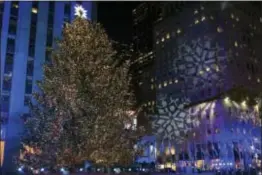  ?? PHOTO BY CHARLES SYKES/INVISION/AP ?? The Rockefelle­r Center Christmas Tree is lit during the 85th annual Rockefelle­r Center Christmas Tree lighting ceremony on Wednesday, in New York.