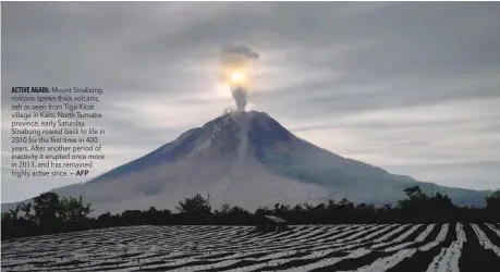  ?? — AFP ?? Mount Sinabung volcano spews thick volcanic ash as seen from Tiga Kicat village in Karo, North Sumatra province, early Saturday. Sinabung roared back to life in 2010 for the first time in 400 years. After another period of inactivity it erupted once...