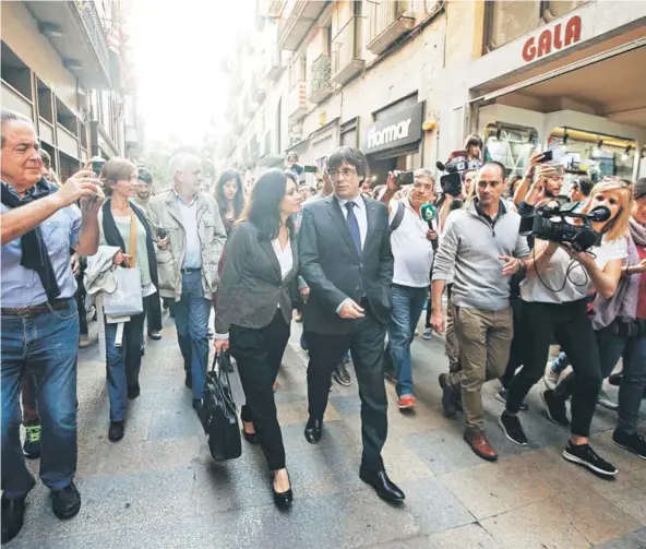  ??  ?? ► El líder catalán, Carles Puigdemont, junto a su esposa caminan ayer por las calles de Girona.