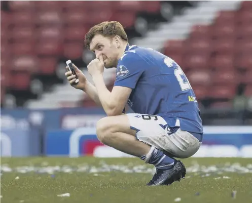  ??  ?? 0 An emotional Liam Craig speaks to his family on his mobile phone following St Johnstone’s Betfred Cup win over Livingston