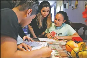  ??  ?? Claudia Bahena (right), 21, of Burlington, N.C., is helped to register to vote during a voter registrati­on drive by community activists. At left is Lizet Miranda, who offered her home as a site for neighbors who are eligible to register.