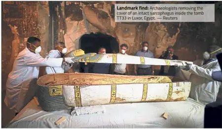  ?? — Reuters ?? Landmark find: Archaeolog­ists removing the cover of an intact sarcophagu­s inside the tomb TT33 in Luxor, Egypt.