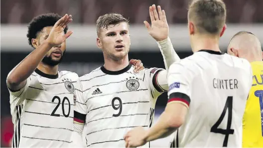  ?? AP-BILD: Michael Sohn ?? Spielten trotz fünf Corona-Fällen beim Gegner: Timo Werner (Mitte) lässt sich für eines seiner beiden Tore gegen die Ukraine von Serge Gnabry (links) und Matthias Ginter feiern.