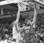  ?? Craig Lassig / Associated Press ?? Minnesota’s Karl-Anthony Towns (32) goes for a dunk as Maxi Kleber defends during Friday’s game.