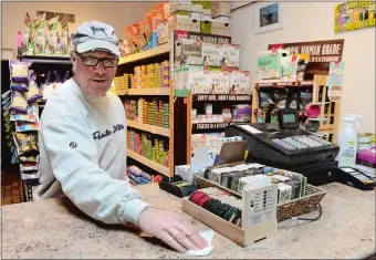  ?? DANA JENSEN/THE DAY ?? John Creaturo, owner of Mystic Pet Shop, uses a disinfecti­ng wipe Tuesday to clean the sales counter in his store in downtown Mystic. He also is cleaning the credit card machines, cash register and the door handles at the entrance every 40 minutes to an hour, depending on how busy the store is during the time.