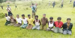  ?? (Reuters) ?? ROHINGYA MUSLIM MEN with their hands bound kneel as members of the Myanmar security forces stand guard in Inn Din on September 2. Shortly after, all 10 were executed.