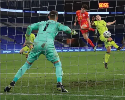  ??  ?? Daniel James rises highest to head home the winner for Wales with 10 minutes to play last night