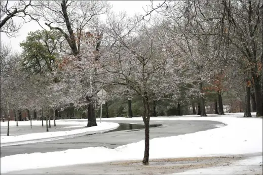  ?? Photos by Ernest A. Brown ?? Ice coats trees and roads at Slater Park as colder temperatur­es overspread the area Friday turning plain rain to sleet and freezing rain, closing school districts throughout the state on Friday.