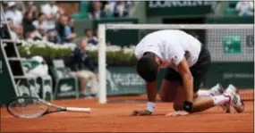  ?? CHRISTOPHE ENA — THE ASSOCIATED PRESS ?? Novak Djokovic falls as he plays Dominic Thiem during match at the French Open Wednesday in Paris. their quarterfin­al