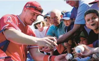  ?? ROSS D. FRANKLIN/AP ?? The Angels’ Mike Trout signs autographs for fans prior to the team’s spring training game against the Dodgers on March 3 in Tempe, Ariz.