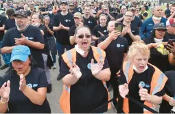  ?? DAVID RICHARD/AP ?? Ford Motor Co. workers react Thursday in Avon Lake, Ohio, to news that the automaker will be expanding the facility in order to build a new commercial electric vehicle.