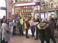  ?? Associated Press ?? Police officers stand at the entrance of Oxford Circus subway station in the west of London after it was reopened on Friday.