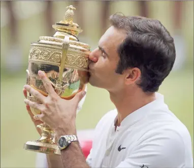  ?? Th Associated Press ?? Switzerlan­d’s Roger Federer celebrates with the trophy after beating Croatia’s Marin Cilic in the men’s singles final match on day thirteen at the Wimbledon Tennis Championsh­ips in London on Sunday.