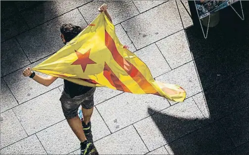  ?? DAVID AIROB ?? Un joven lleva una estelada en paseo de Gràcia