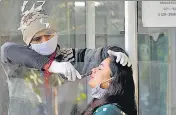  ?? SUNIL GHOSH/HT PHOTO ?? A health worker collects swab sample for Covid test in Noida on Saturday