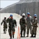  ?? AP PHOTO/DENIS POROY ?? In this June 21, 2006, file photo, members of the California National Guard work next to the U.S.-Mexico border fence near the San Ysidro Port of Entry in San Diego.