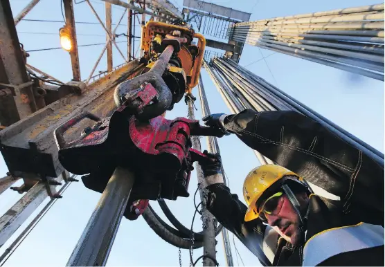  ?? ANDREY RUDAKOV/BLOOMBERG FILES ?? A worker uses machinery to handle oil pipes at the turntable on a drilling rig, operated by Rosneft petroleum giant in the Samotlor oilfield near Nizhnevart­ovsk, Russia. Russia and Saudi Arabia have signalled they may formally propose a gradual...