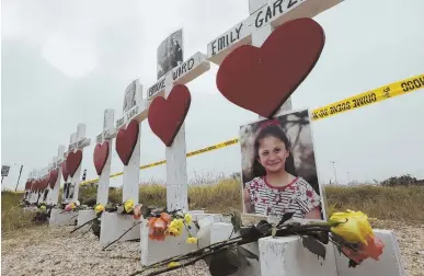  ?? AP PHOTO ?? IN MEMORY: Crosses showing the shooting victims’ names and some of their pictures stand near the First Baptist Church yesterday in Sutherland Springs, Texas.