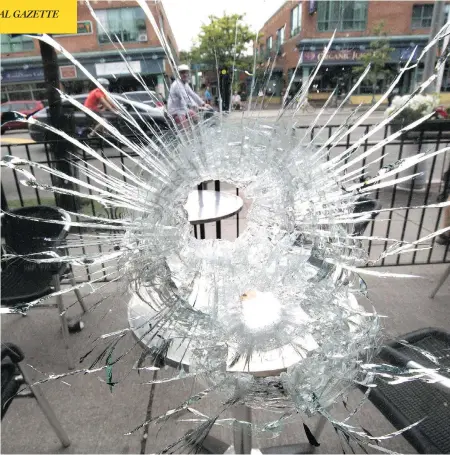  ?? CRAIG ROBERTSON/POSTMEDIA NEWS ?? A bullet hole in the window of the Second Cup on Danforth Avenue in Toronto is part of the aftermath of Sunday night’s shooting spree.