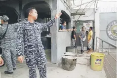  ??  ?? A prison personnel gestures during an interview following the escape of more than 150 inmates after gunmen stormed a prison in North Cotabato province, southern Philippine­s. — Reuters photo