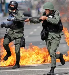  ??  ?? Chaos: Riot police at an anti-regime protest in Caracas