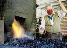  ?? COLONIAL WILLIAMSBU­RG ?? Master blacksmith Ken Schwartz gets to work, demonstrat­ing the trade, at the reopening this summer of Colonial Williamsbu­rg.