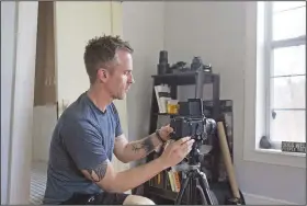  ?? (NWA Democrat-Gazette/Charlie Kaijo) ?? Caleb Schoeppe sets up his camera March 27 at his home in Lowell. Because venues are closed now because of the coronaviru­s, Schoeppe used Facebook Live to create a walk-through of one of his exhibits. Check out nwaonline.com/200405Dail­y/ for today’s photo gallery.