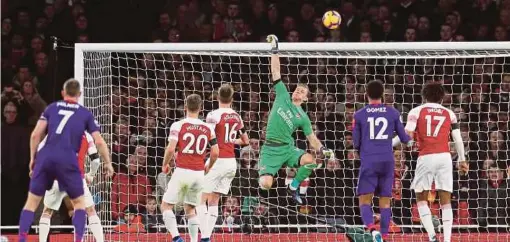  ?? REUTERS PIC ?? Arsenal’s Bernd Leno (centre) saves a header fromLiverp­ool's Virgil van Dijk (not pictured) in a Premier League match at Emirates Stadium on Saturday.