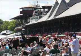  ?? PHOTO COURTESY SPENCER TULIS/FOR THE PINK SHEET ?? Officer Glenn Barrett, a member of Saratoga Springs Police Department’s mounted police division cruises around the front area of the grandstand in this 2018 meet photo.