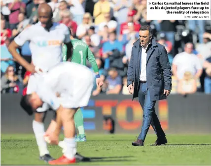  ?? HUW EVANS AGENCY ?? &gt; Carlos Carvalhal leaves the field as his dejected players face up to the reality of relegation