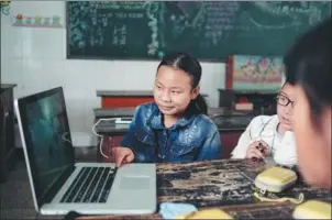  ?? PHOTOS PROVIDED TO CHINA DAILY ?? A group of students at the Anding Primary School in Jingdong Yi autonomous county of Yunnan province appreciate photos in a photograph­y class.