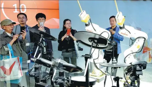  ?? LONG WEI / FOR CHINA DAILY ?? Robots made by German manufactur­er Kuka AG play percussion at an exhibition in Shanghai.