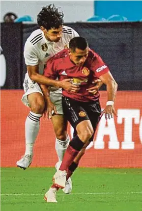  ?? AFP PIC ?? Manchester United’s Alexis Sanchez is held back by Real Madrid’s Jesus Vallejo on Tuesday.