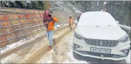  ?? DEEPAK SANSTA/HT ?? A family walks on a snow-covered road in Shimla on Saturday.