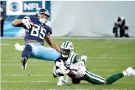  ?? AP Photo/James Kenney ?? ■ Tennessee Titans tight end MyCole Pruitt (85) is brought down by New York Jets strong safety Jamal Adams, right, in the first half Sunday in Nashville, Tenn.