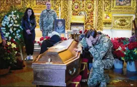  ?? EFREM LUKATSKY/AP ?? A soldier pays his last tribute to volunteer soldier Oleksandr Makhov, 36, a well-known Ukrainian journalist who was killed by Russian troops, during his funeral at St. Michael cathedral in Kyiv, Ukraine, on Monday.